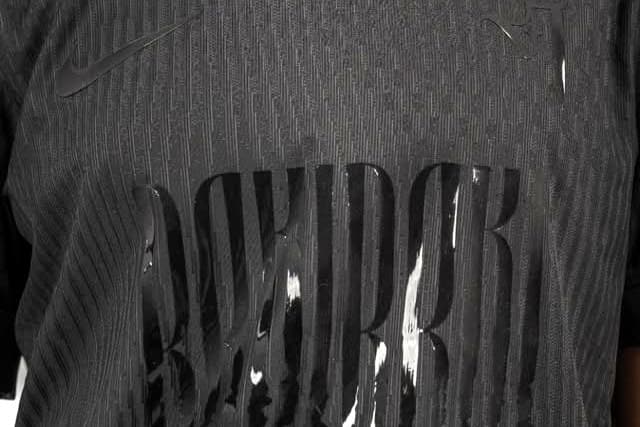 Le maillot noir du FC Rocquancourt, porté : grande inscription ton sur ton, en relief brillant.